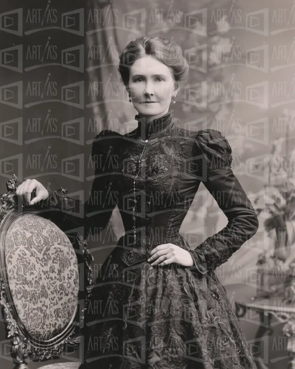 Retrato de mujer con vestido negro y peinado recogido, posando junto a una silla decorativa. | CUADROS DE ATREZZO PARA CINE Y PUBLICIDAD