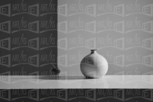 Composición minimalista con un jarrón blanco y una manzana sobre una mesa. | CUADROS DE ATREZZO PARA CINE Y PUBLICIDAD